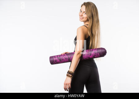 Vista posteriore ritratto di una giovane donna di fitness con materassino yoga su sfondo bianco Foto Stock