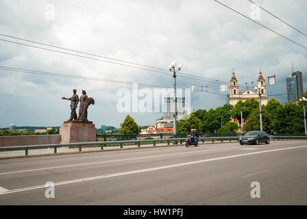 Vista sul ponte verde con il traffico e la statua di un uomo e di una donna contro di cielo nuvoloso. Foto Stock