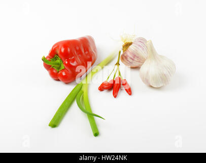 Dolce rosso pepe, peperoncino, lo scalogno e l'aglio su sfondo bianco Foto Stock