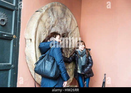 Roma, Italia - 2 Gennaio 2017: La Bocca della Verita' (la Bocca della Verità) con due ragazze nel portico della chiesa di Santa Maria in Cosmedin in ro Foto Stock