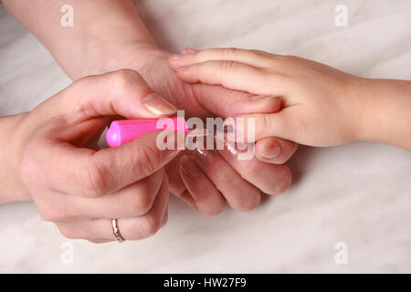 Mani Mom causando manicure smalto per unghie a figlia Foto Stock