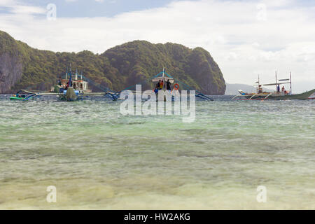 La tradizione della pompa filippino di barche di riva di un paradise island sperando gita turistica con lo sfondo di una delle isole. Foto Stock