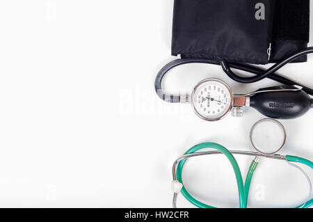 Health care concetto - sangue preasure bracciale, monitor e uno stetoscopio su sfondo bianco Foto Stock