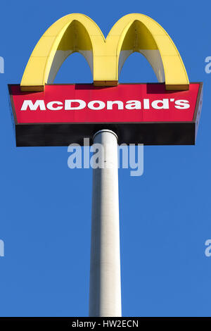 McDonald's signpost contro il cielo blu. McDonald è un americano di hamburger e un ristorante fast food chain, fondata nel 1940. Foto Stock