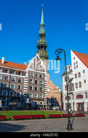 Edifici residenziali su Albert Square sulla Città Vecchia di Riga, la città capitale della Repubblica di Lettonia. Il campanile della chiesa di San Pietro sullo sfondo Foto Stock
