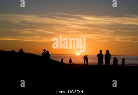 Un giovane abbraccia sulla spiaggia come i tramonti a Venice Beach in California Foto Stock