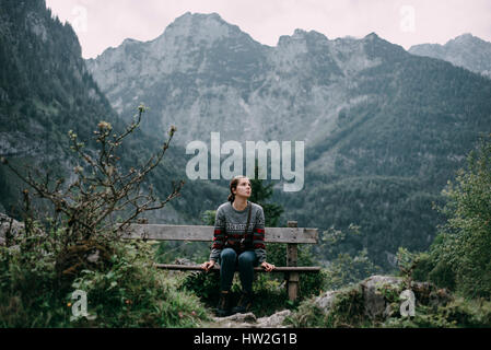 Caucasian donna seduta sul banco in montagna Foto Stock