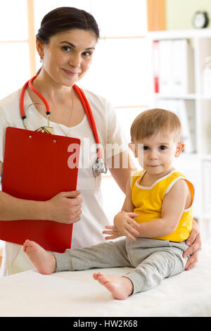 Medico pediatra esaminando kid Foto Stock