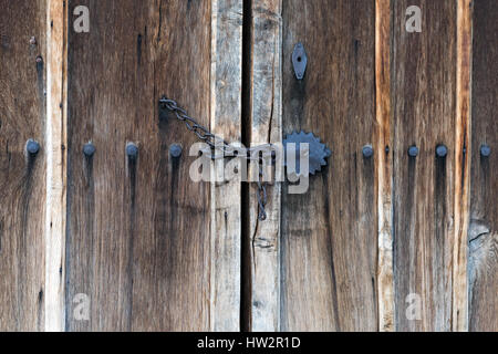 Bloccato a catena porta in legno con grandi chiodi di ferro e ornamenti in metallo Foto Stock