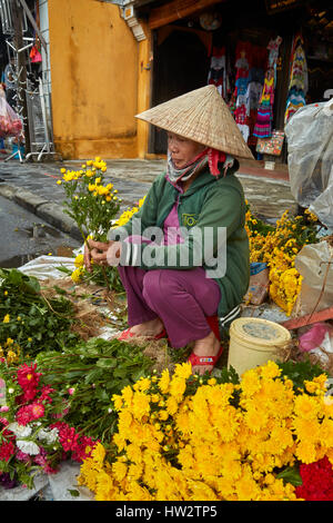 Donna che vendono fiori, Hoi An (Patrimonio Mondiale dell'UNESCO), Vietnam Foto Stock