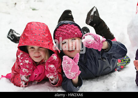 I bambini che giocano sulla neve, Dublino, Irlanda Bimbo bimba gioia divertimento, concetto infanzia felice, divertimento invernale Foto Stock