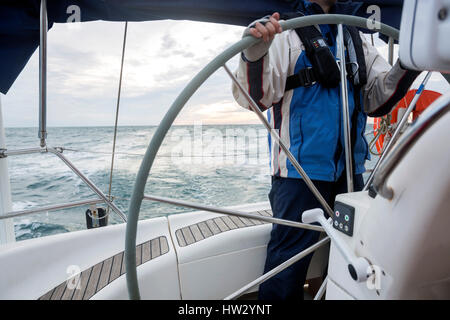 Sezione mediana dell'uomo volante di yacht in mare al tramonto Foto Stock