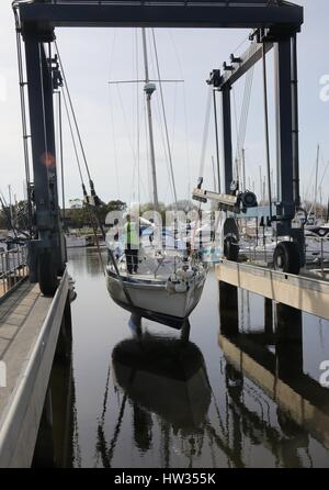 14MARZO 2017,CHICHESTER,Inghilterra: uno yacht essendo calata in acqua utilizzando una barca culla fionda in chichester marina ,l'inghilterra Foto Stock