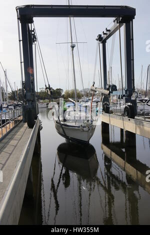 14MARZO 2017,CHICHESTER,Inghilterra: uno yacht essendo calata in acqua utilizzando una barca culla fionda in chichester marina ,l'Inghilterra il 14 marzo 201 Foto Stock