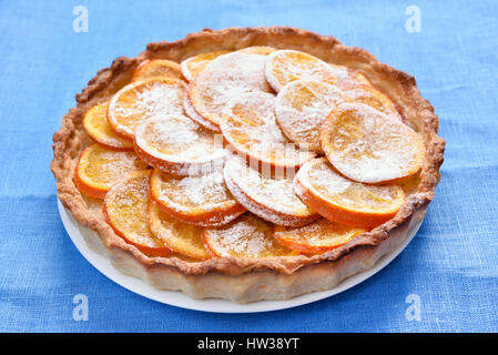 Torta di colore arancione su sfondo blu, vista ravvicinata Foto Stock