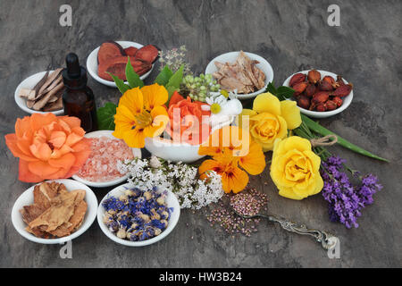 Fiore e selezione di erbe utilizzate in alternativa naturale a base di erbe con olio essenziale di biberon e mortaio con pestello. Foto Stock