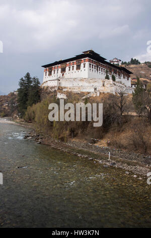 Il Bhutan, Paro, Rinpung Dzong. Paro River (Paro Chhu) Vista del XV secolo il monastero buddista e fortezza. Historic Ta Dzong (torre di avvistamento) nel di Foto Stock