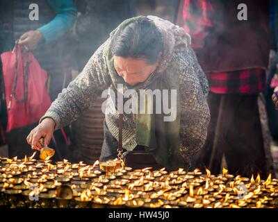 Kathmandu, Sviluppo Centrale Regione, Nepal. Xvii Mar, 2017. Una donna luci di lampade a burro ad un tibetano monastero buddista accanto alla Stupa Boudhanath a Kathmandu. Stupa Boudhanath è il sito più sacro nel buddismo nepalese. È anche il centro dell'esilio tibetano comunità di Kathmandu. Lo stupa fu gravemente danneggiata nel terremoto 2015 ma è stato uno dei primi edifici rinnovati. Foto da JACK KURTZ Credit: Jack Kurtz/ZUMA filo/Alamy Live News Foto Stock