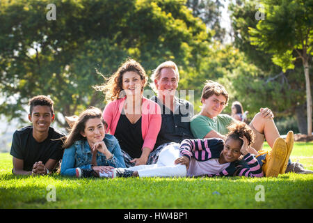 Ritratto di famiglia sorridente di erba in posizione di parcheggio Foto Stock