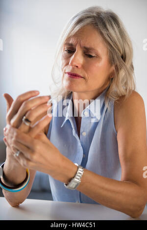 La donna caucasica sfregamento in mano il dolore Foto Stock