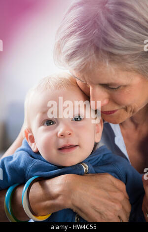 Ritratto di sorridente nonna caucasica abbracciando baby nipote Foto Stock