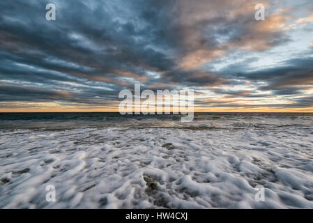 Schiuma di onde sulla spiaggia dell'oceano Foto Stock