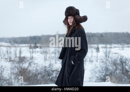 Grave donna caucasica indossando cappello di pelliccia e rivestire in inverno Foto Stock