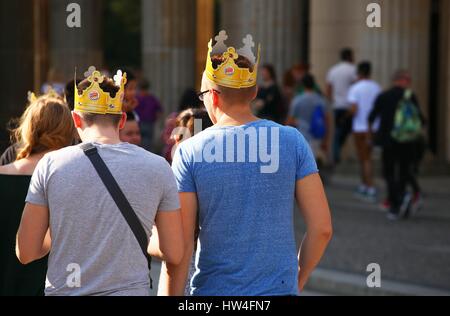 Due giovani turisti usura Burger King corone di carta come essi a piedi di fronte alla Porta di Brandeburgo a Berlino il 09 settembre 2015. Questa immagine è parte di una serie di foto sul turismo a Berlino. Foto: Wolfram Steinberg/dpa | Utilizzo di tutto il mondo Foto Stock