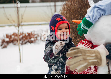 Bambina giocando con il pupazzo di neve Foto Stock