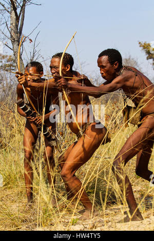 I Boscimani persone che simula una battuta di caccia con arco e frecce a Grashoek, Namibia settentrionale Foto Stock