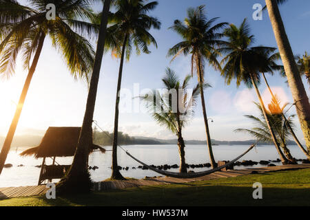 Vista della spiaggia tropicale con palme di cocco,hut e culla a Phuket, Tailandia. Estate, Viaggi, vacanze e concetto di vacanza. Foto Stock