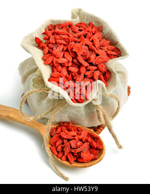 Bacche di Goji nel sacco sacco con il cucchiaio di legno isolato su bianco Foto Stock