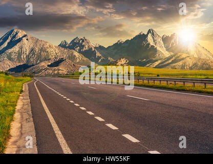 Destinazione di viaggio Concetto di immagine. Paesaggio composito dei Monti Tatra montagna cresta al tramonto. Asfalto semplice autostrada attraverso colline verdi conduce a hi Foto Stock