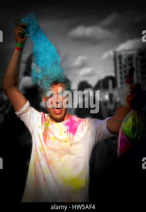 Uomo di gettare polvere colorata in aria a Holi festival, Battersea Power Station di Londra, Inghilterra, Regno Unito Foto Stock