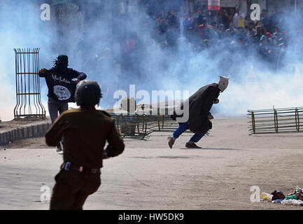 La questione del Kashmir, India. Xvii Mar, 2017. Un musulmano del Kashmir protester viene eseguito come i gas lacrimogeni barattolo sparati dalla polizia indiana esplode nel vecchio Srinagar la capitale estiva della controllata indiana del Kashmir. Proteste e scontri eruttare nel vecchio contro le recenti uccisioni di civili da parte del governo indiano le forze in Kashmir. In precedenza questa settimana a 7 yr old girl è stato ucciso dalle forze del governo nel corso di una sparatoria tra i miliziani e le forze governative del nord del Kashmir Kupwara. Credito: Faisal Khan/Pacific Press/Alamy Live News Foto Stock