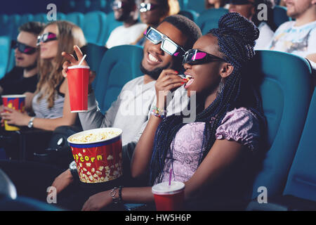 Paio di africani mangiare popcorn, bere cola nei cinema. Foto Stock