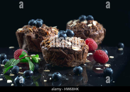 Oat muffin con mirtilli su sfondo scuro. Foto Stock