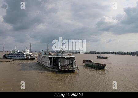 Il fiume Mekong in Indocina, semplicemente la barca di legno sul fiume sporco con case a pilastri. colorata unica barca Foto Stock