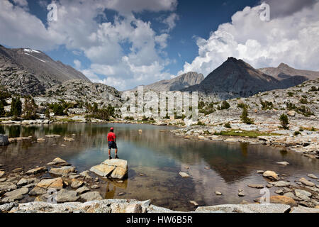 CA03099-00...CALIFORNIA - escursionista un tarn su Darwin in Panchina il Kings Canyon Wilderness. Foto Stock