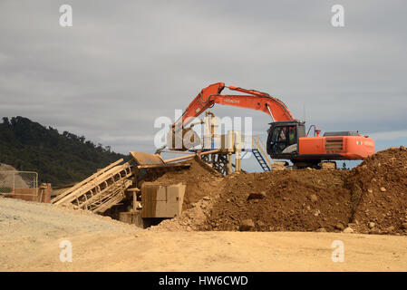 ROSS, Nuova Zelanda, 10 marzo 2017: un Gold Miner paydirt feed da una miniera a cielo aperto nella schermata che separerà i oro. Foto Stock