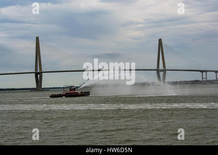 Rimorchiatore "Jeffery McAllister' spruzza acqua da esso fire ugelli in Cooper River con la Arthur Ravenel Jr ponte in background Foto Stock