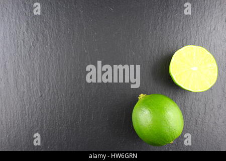 Lime fresco frutta su una piastra di ardesia come un cibo texture di sfondo Foto Stock