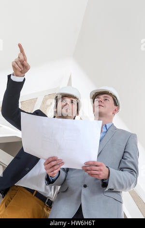 Due ingegnere o architetto discutere sul progetto al sito in costruzione in bianco envuronment Foto Stock