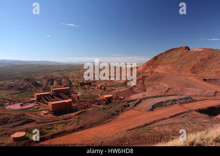 Il minerale di ferro di scarico degli autocarri, il convogliatore e archiviano nelle gamme Hamersley Pilbara Australia Occidentale Foto Stock