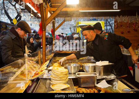 Il cibo. Un uomo per la cottura del tipico langos, Mercato di Natale. Budapest Ungheria, Europa sud-orientale Foto Stock