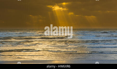 Alcuni splendidi raggi di luce del sole raggiante attraverso nuvole temporalesche. Foto Stock