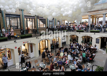 Le luci di natale e occupato il natale le bancarelle del mercato all'interno di covent garden, la City of Westminster, Londra, Inghilterra, Regno Unito Foto Stock