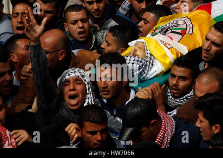 Hebron, Palestina. Xviii Mar, 2017. (Nota dell'Editore: immagine raffigura la morte.) lutto portano il corpo di sedici anni Mourad palestinese Youssef Abu Ghazi durante il suo funerale in Arroub Refugee Camp vicino al West Bank città di Hebron. Mourad è stato ucciso dai soldati israeliani un giorno prima durante gli scontri. Credito: Osama Qawasmi/Pacific Press/Alamy Live News Foto Stock