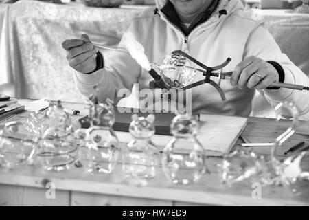 Artigiano decorazione di oggetti in vetro utilizzando una torcia. Foto Stock