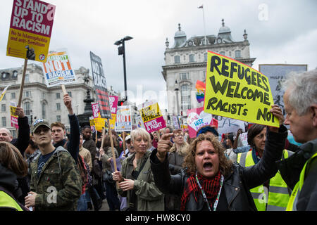 Londra, Regno Unito. Il 18 marzo, 2017. Anti-razzisti frequentando il marzo contro il razzismo guardare verso una piccola contro-dimostrazione da parte dei membri della Gran Bretagna prima a Piccadilly Circus. Il mese di marzo con la partecipazione di molte migliaia di persone, è stata programmata per avvenire il più vicino possibile all'ONU Giornata Internazionale per l Eliminazione della Discriminazione Razziale. Credito: Mark Kerrison/Alamy Live News Foto Stock